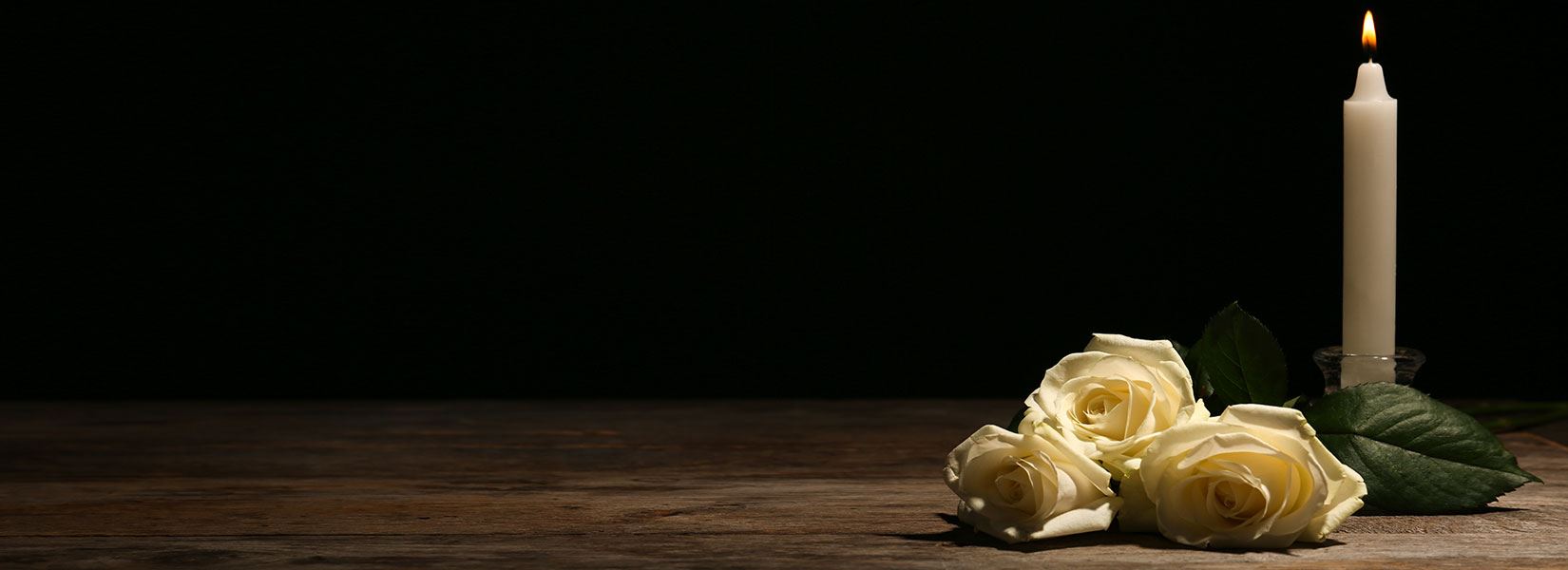 Flowers and a lit candle on a table