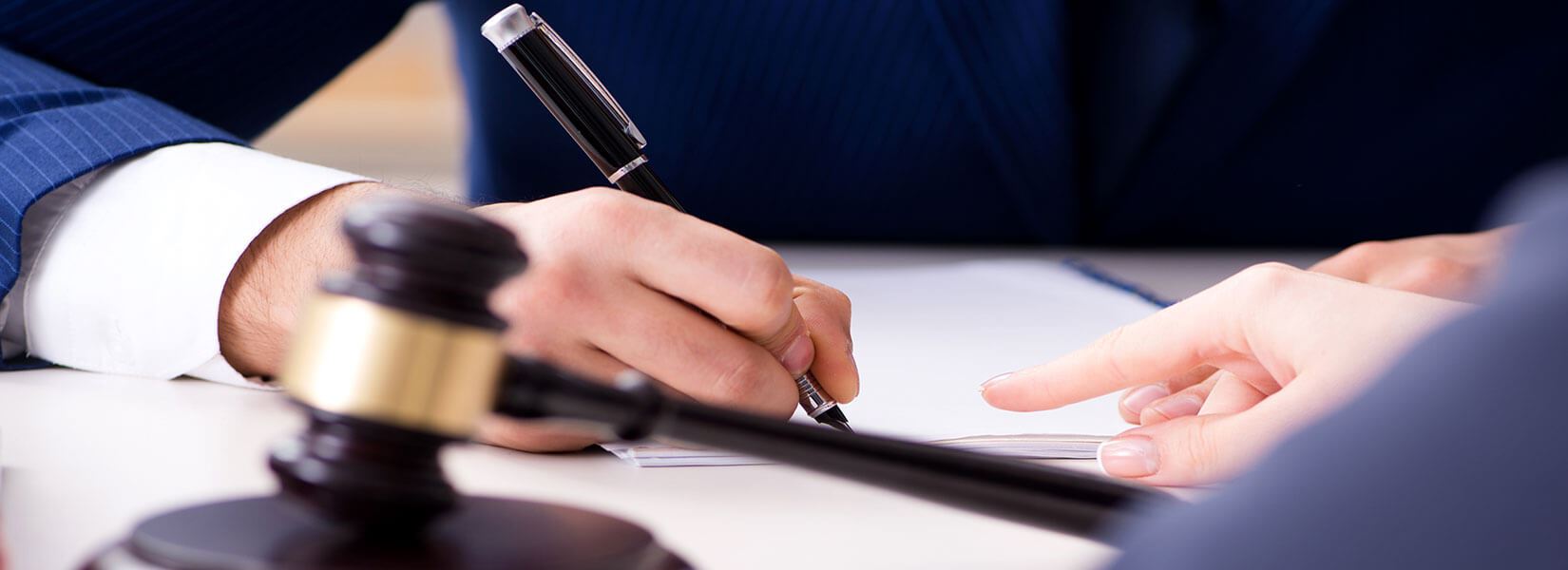 Signing document next to gavel