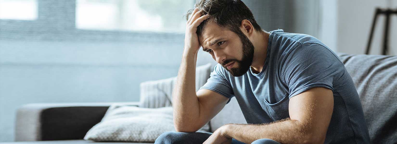 Man sitting with his hand on his head concentrating
