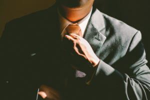 man straightening his neck tie