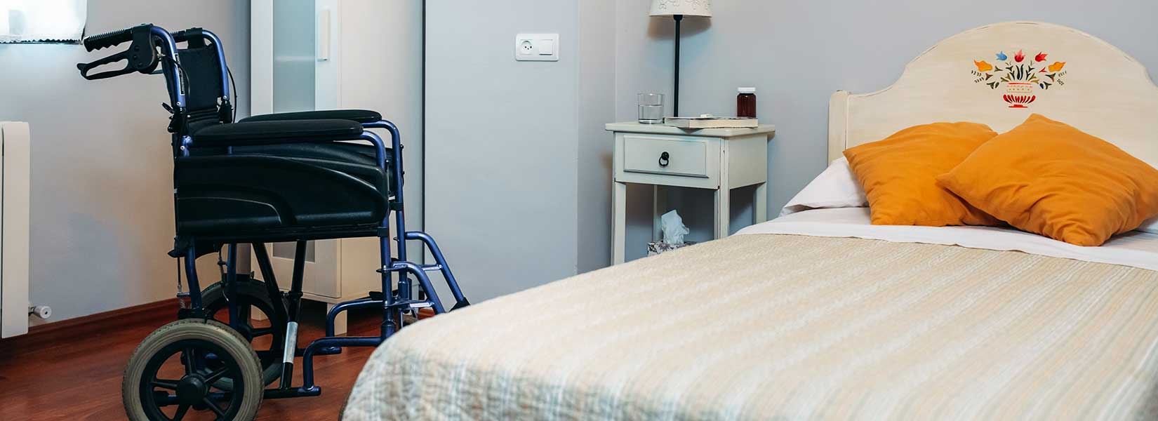A bedroom with a wheelchair in it