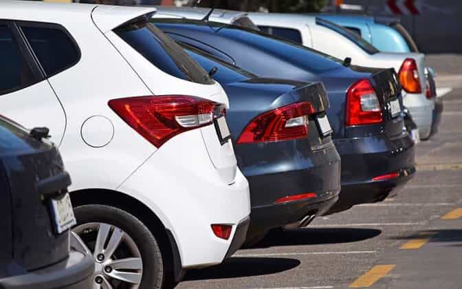 A row of cars in a parking lot