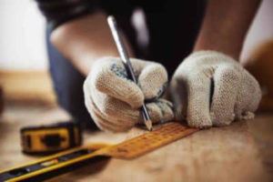 Worker drawing a line with a ruler